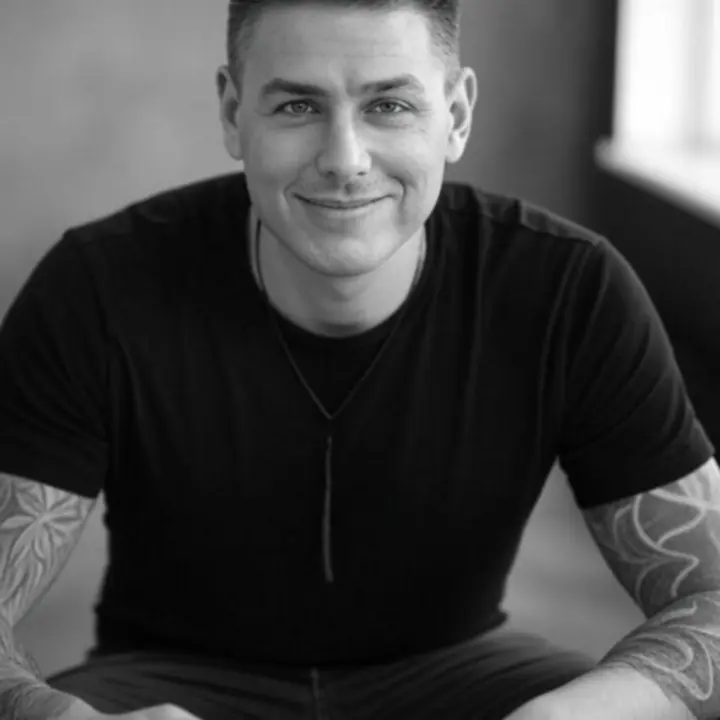 Tetoválóművész fekete-fehér portréja a stúdióban.